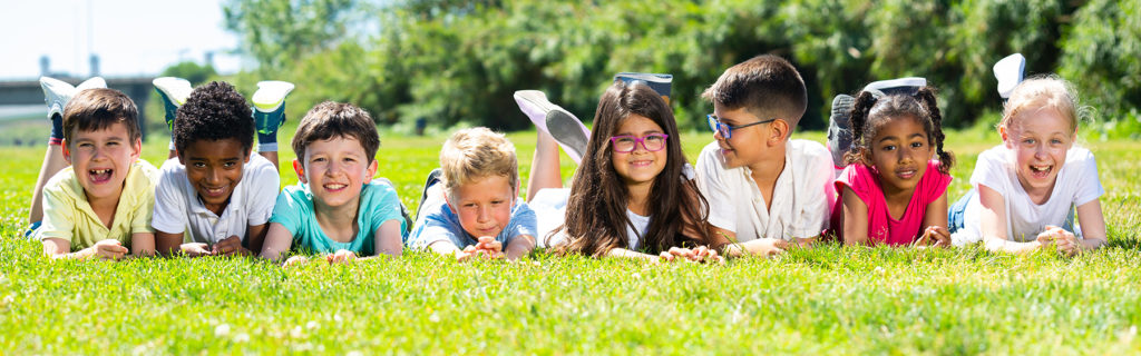 Group of happy children laying on the grass