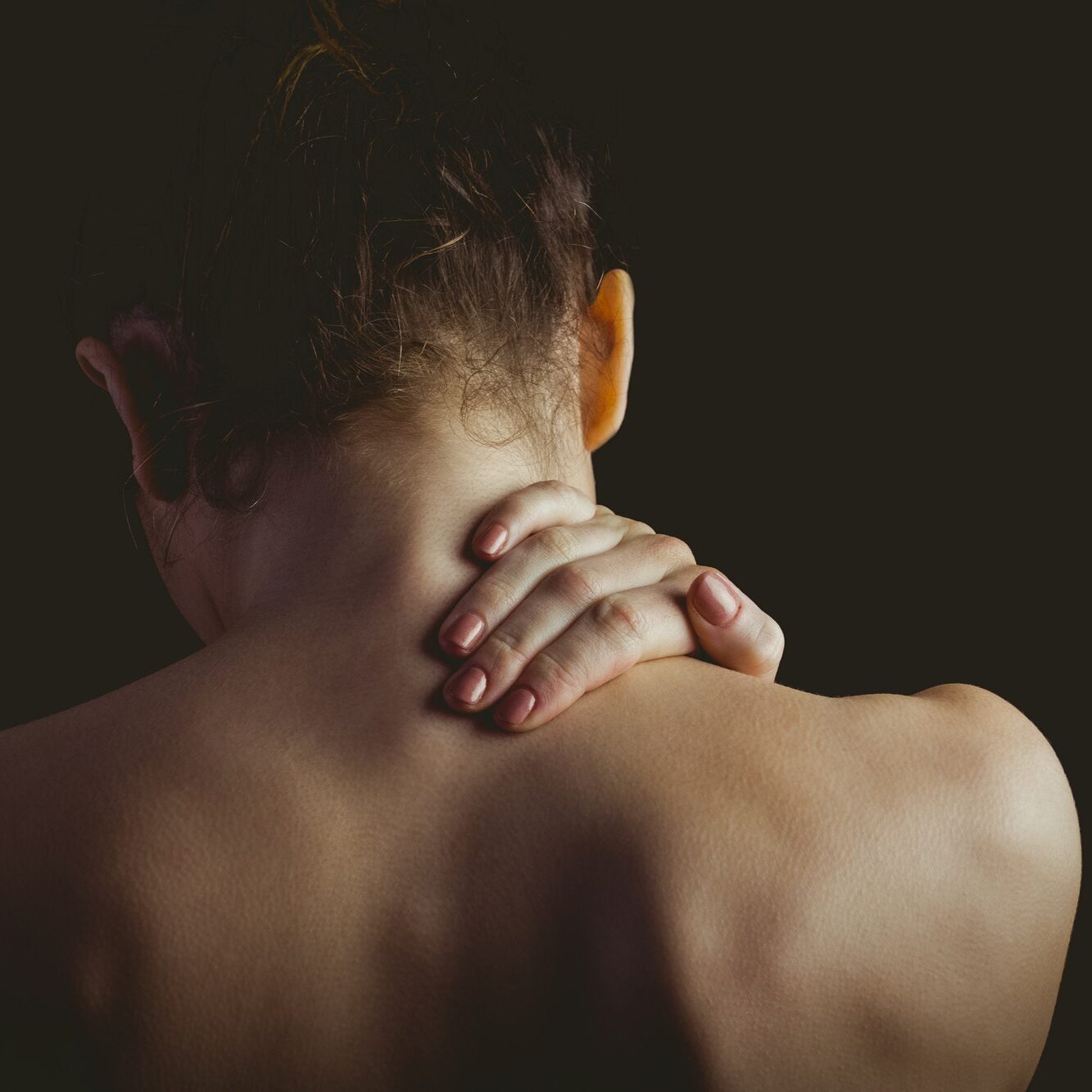 Woman with a neck injury on black background